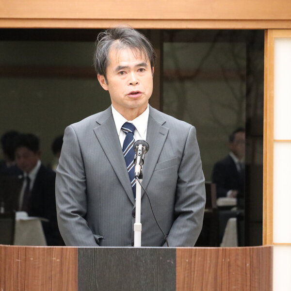 あいさつをする橋本委員長