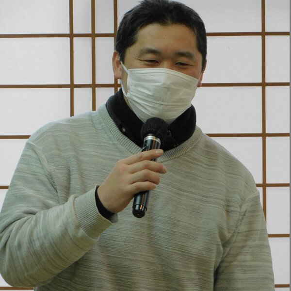 あいさつする坪井部会長