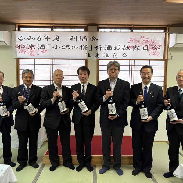新酒を手にする玄葉代表（右から３人目）地産地消会の坪井肇代表（中央）