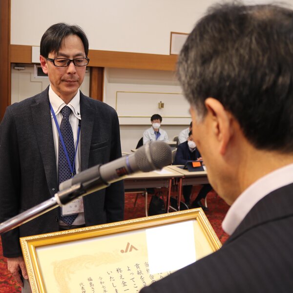 ３０年勤続表彰の賞状を受け取る農業金融センターの加藤祐センター長