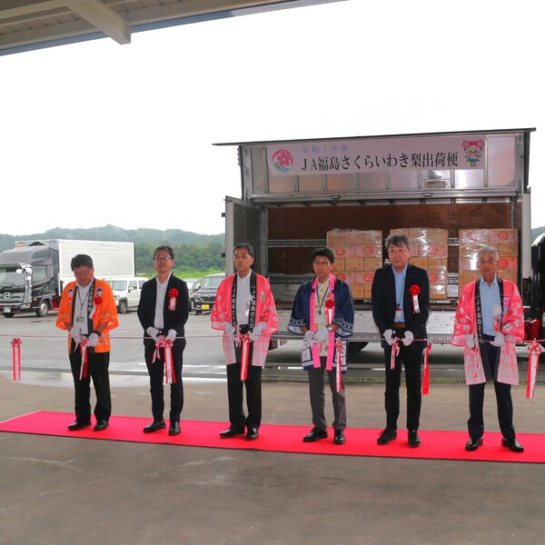 ープカットを行う志賀組合長（左から３番目）ら関係者（ベトナム向け輸出梨出発式）