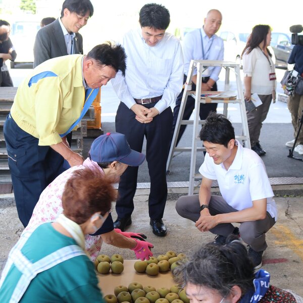 （左から）梨の説明を受ける根本拓議員と椎根健夫郡山市長（郡山地区梨共同選果場開所式）