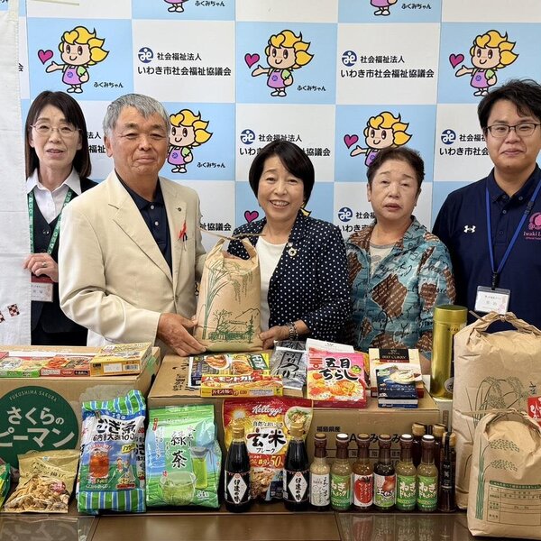 食料品を贈呈する中根理事(中央)と合津部長(右から2番目)